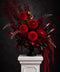 Luxurious burgundy red flower arrangement on white plinth