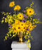 Bouquet of yellow and purple flowers in a gold vase. Featuring orchids and sunflowers