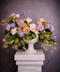 Garden style floral arrangement in a white urn