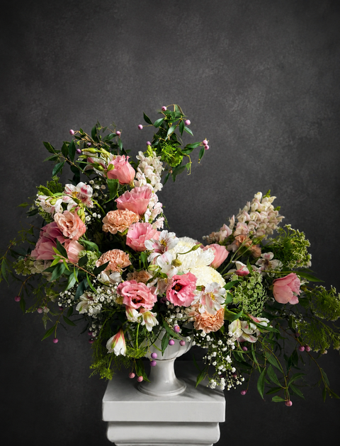 Garden inspired floral arrangement in white urn with pink and peach flowers including Lisianthus and Alstroemeria