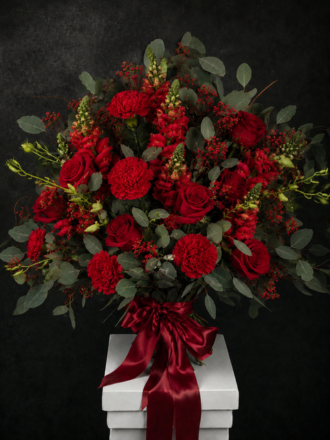 Bouquet of red roses, carnations, orchids and snapdragons with eucalyptus leaves