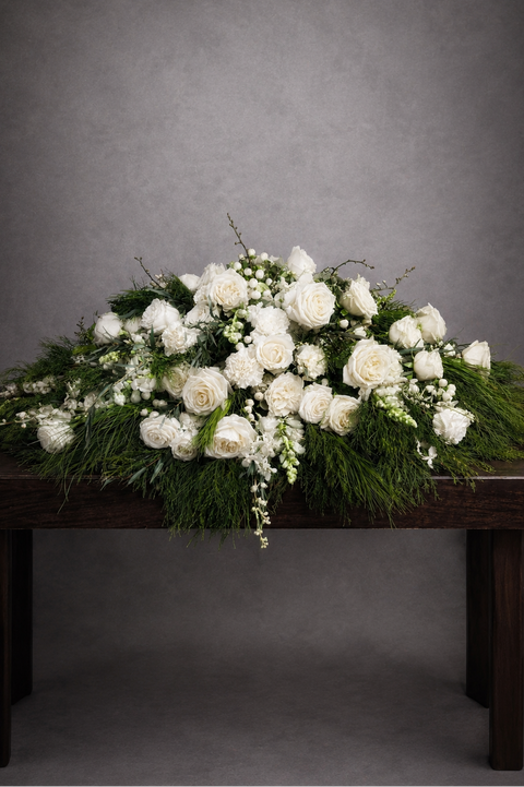 Luxurious white coffin flower spray with roses, orchids, carnations and snapdragons
