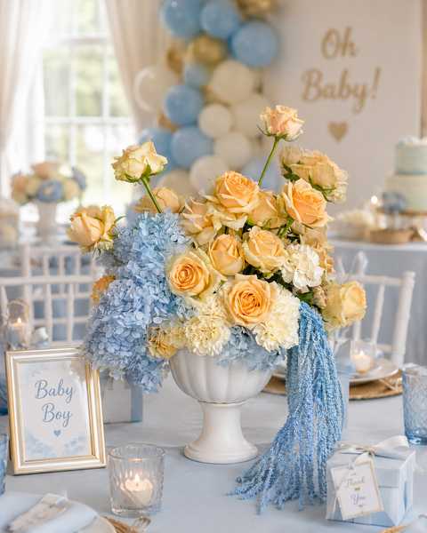 Decorative table setting with flowers, candles, and a 'Baby Boy' sign at a baby shower.