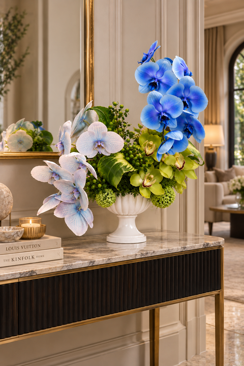 Luxurious blue and green orchid arrangement in a white urn vase, in beautiful hotle on a console table in the foyer