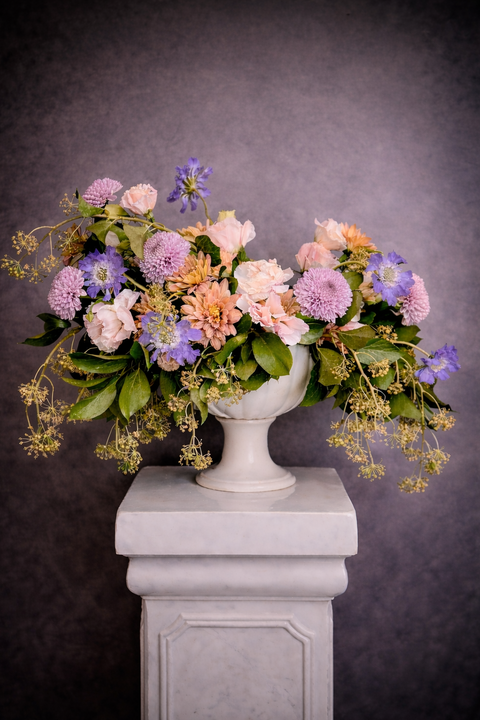 Garden style floral arrangement in a white urn 