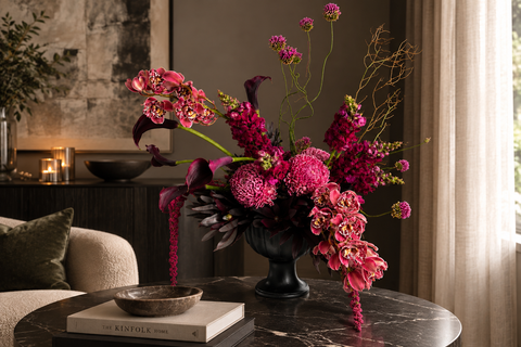 A luxurious burgundy orchid flower arrangement in black vase 