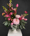 Bouquet of flowers in a white vase  with snapdragons, tulips, roses, chrysanthemum, eucalyptus, oriental lillie