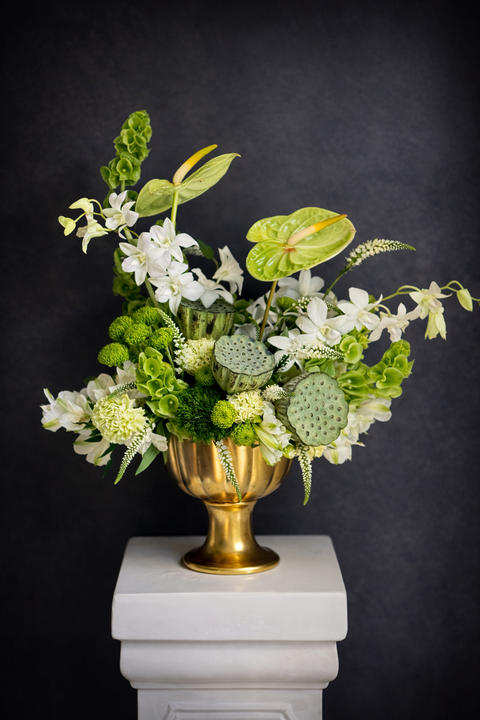 Luxury green and white floral arrangement with orchids, anthurium, and sculptural textures. A modern, elegant statement piece for refined gifting or interiors.