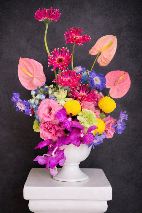 Colorful flower arrangement in a white vase on a dark background