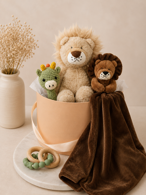 Two lion plush toys with a baby blanket and small dinosaur rattle toy in a hamper including teething ring