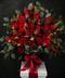 Bouquet of red flowers with eucalyptus leaves, including red roses